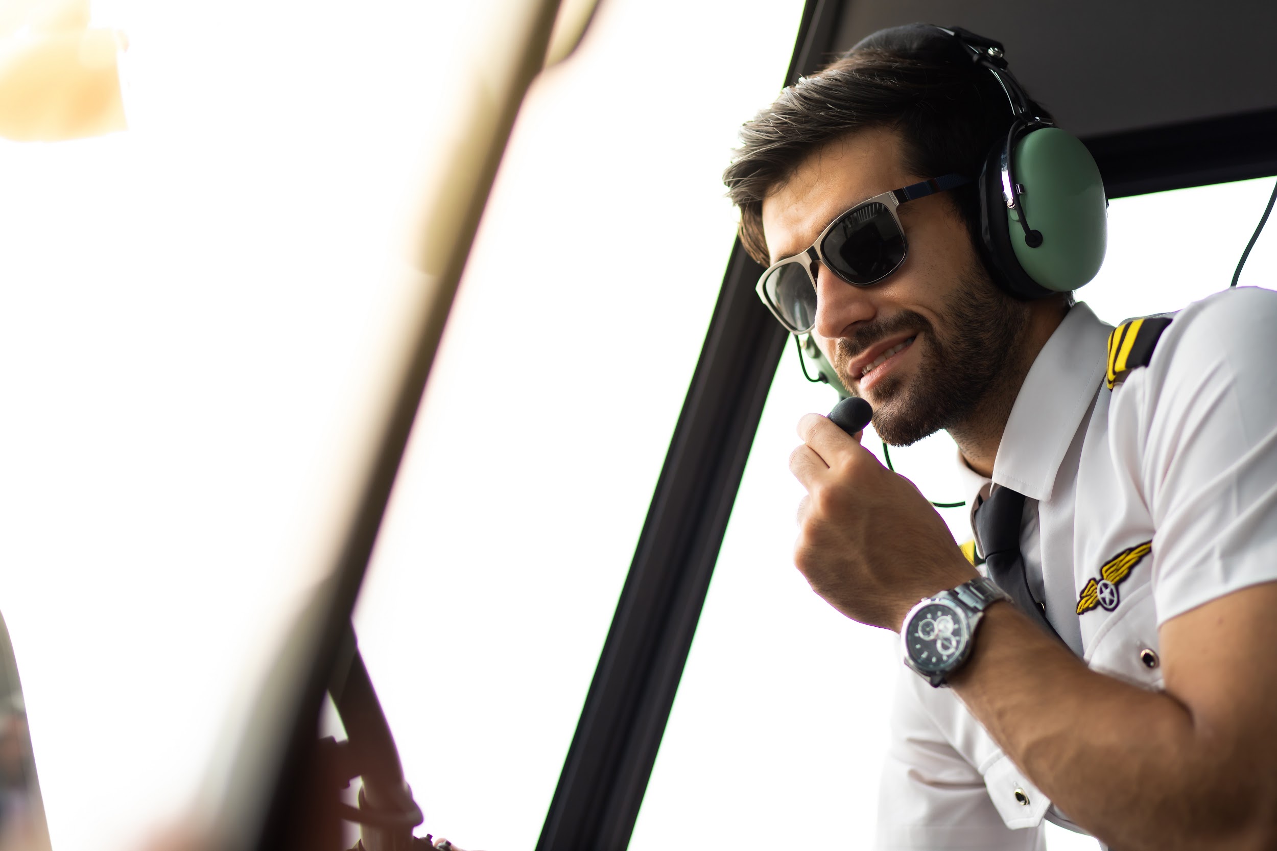 pilot with headset starting the controls in cockpit helicopter