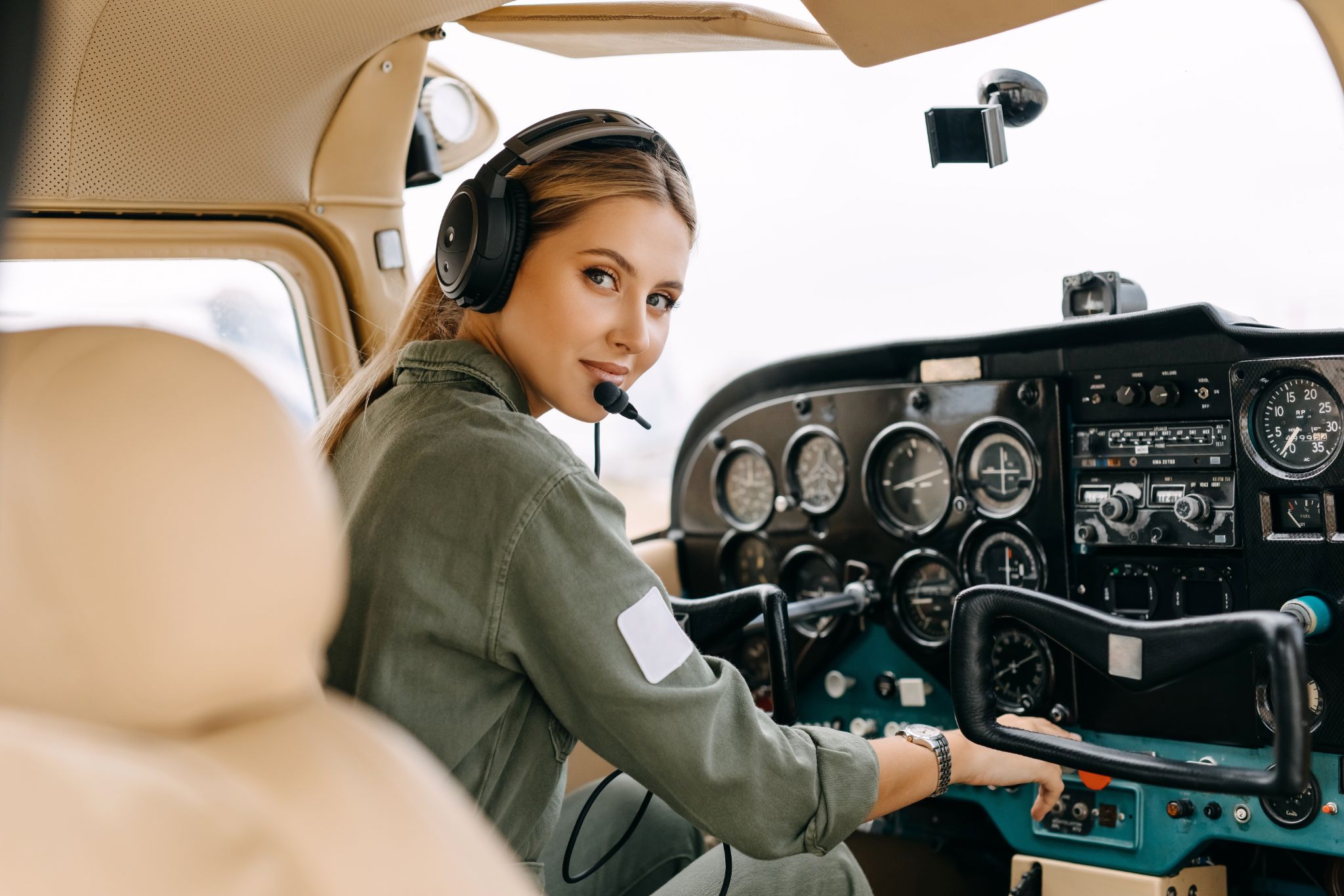 Woman pilot sitting in private airplane cockpit