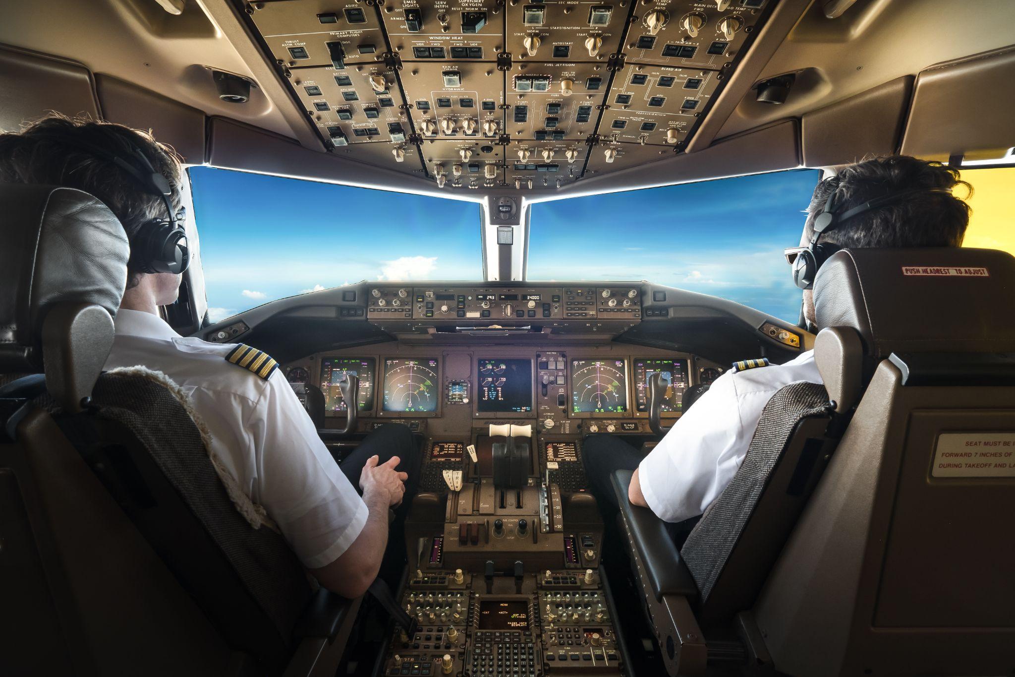 Pilots in the cockpit during a flight with commercial airplane.