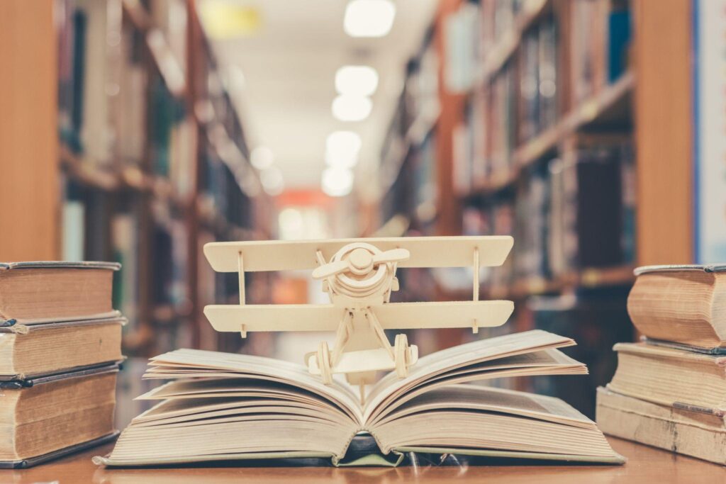 Airplane model on old educational book in library for history education