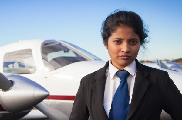 female Indian pilot standing in front of plane