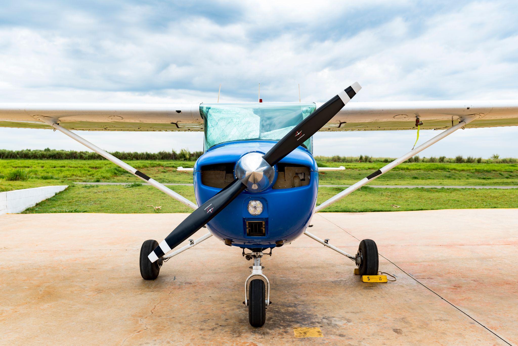 A blue single engine airplane or propeller aircraft on the ground.