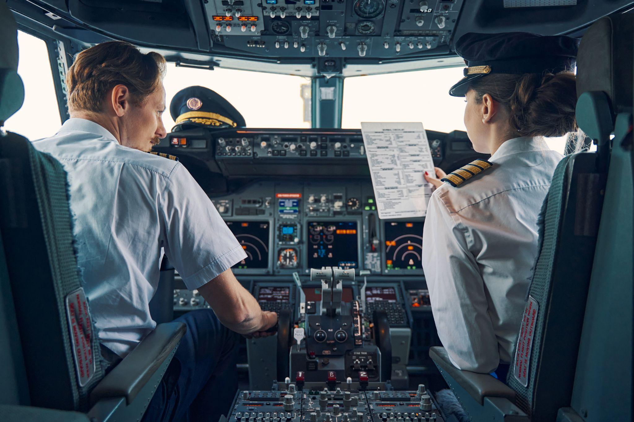 Pilot and female first officer seated in the flight deck.