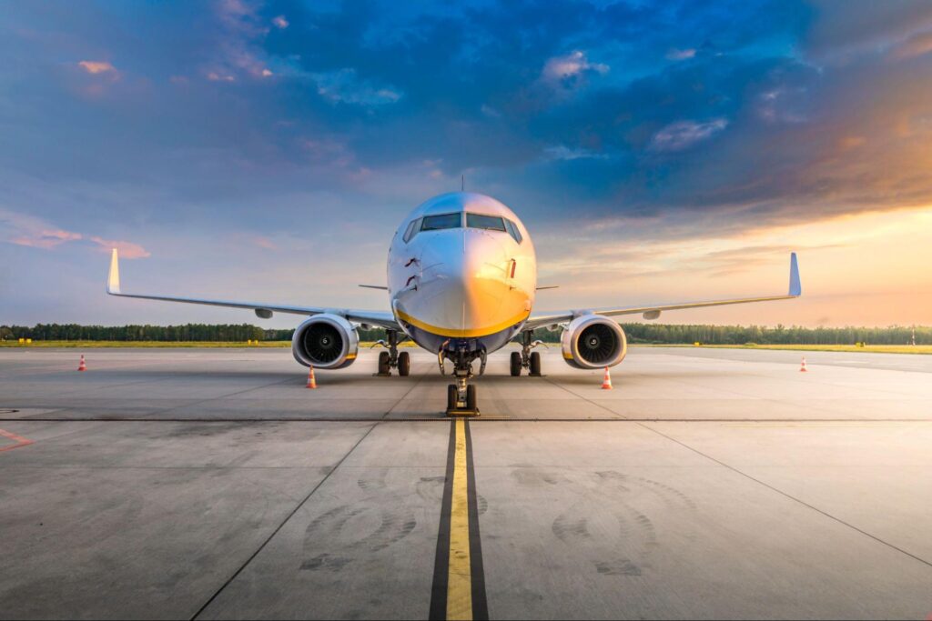 Modern commercial airplane in the parking lot of the airport apron, waiting for services maintenance, refilling fuel, and passenger boarding the plane.
