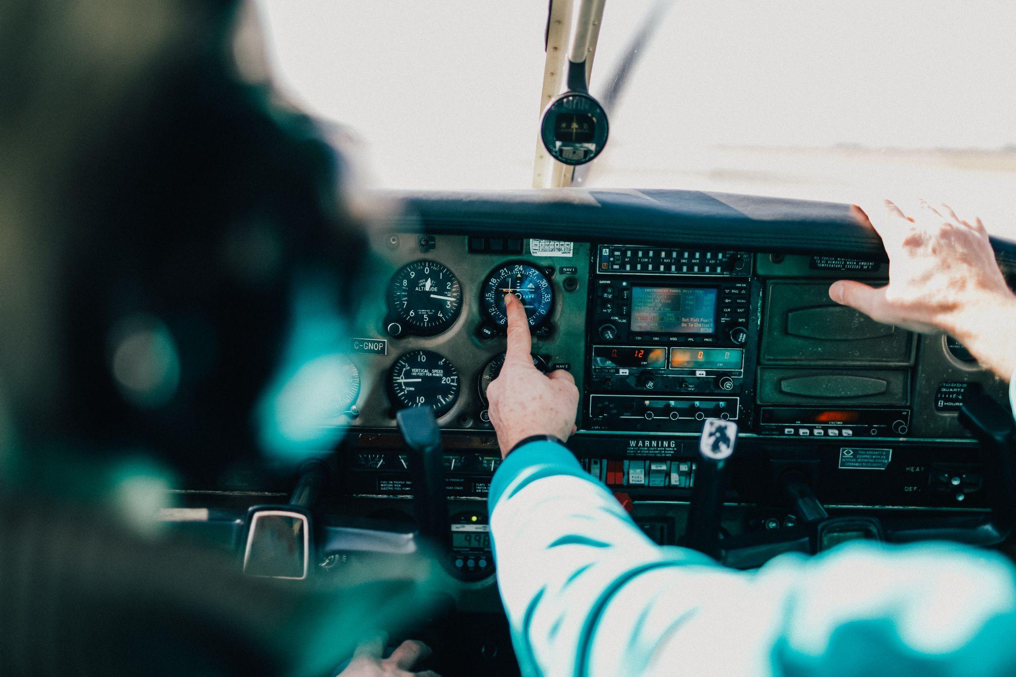 Flight instructor and student inside small Piper aircraft.