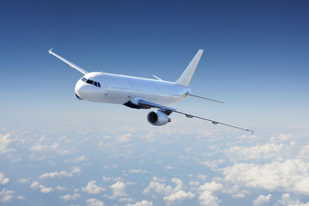 Airplane in the sky, over the cloudy sky.