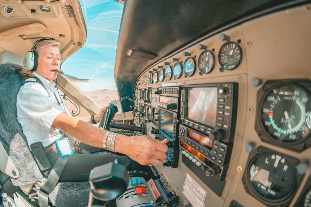 Female pilot adjusting aircraft controls, preparing for a career in aviation.