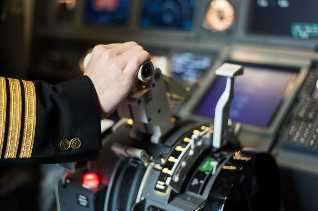 Female pilot's hand on the plane engine control stick.