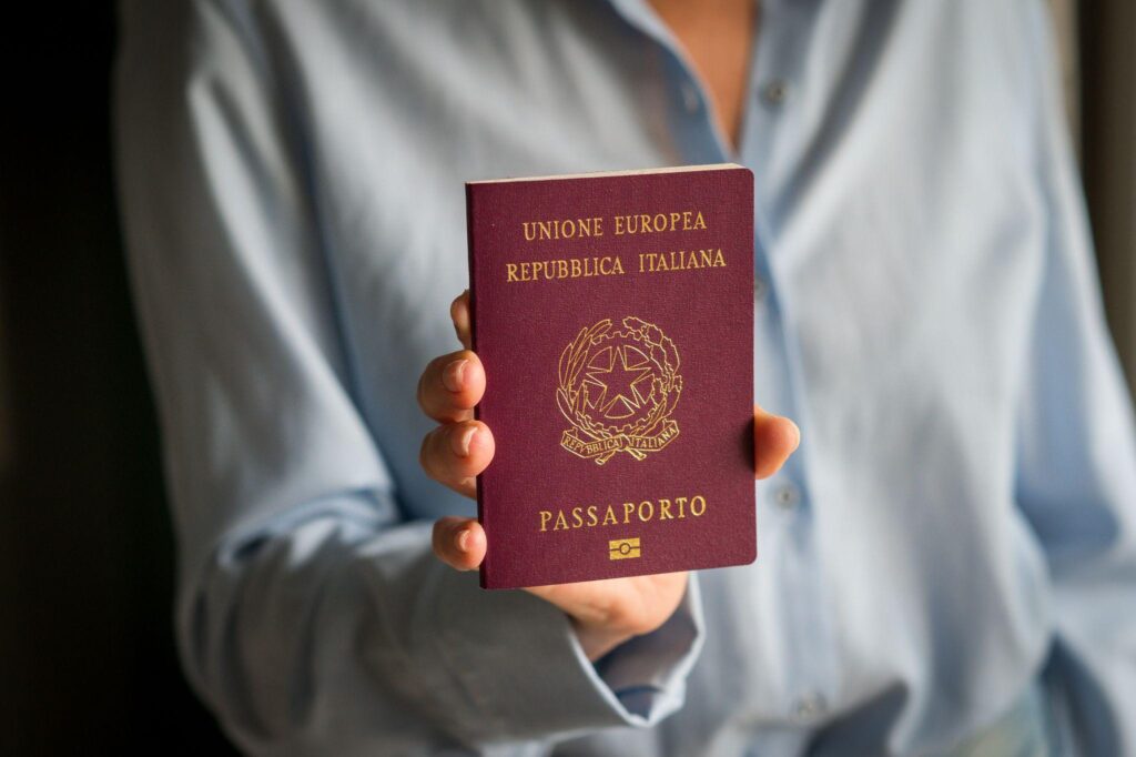 Woman holding Italian passport ready for international travel.