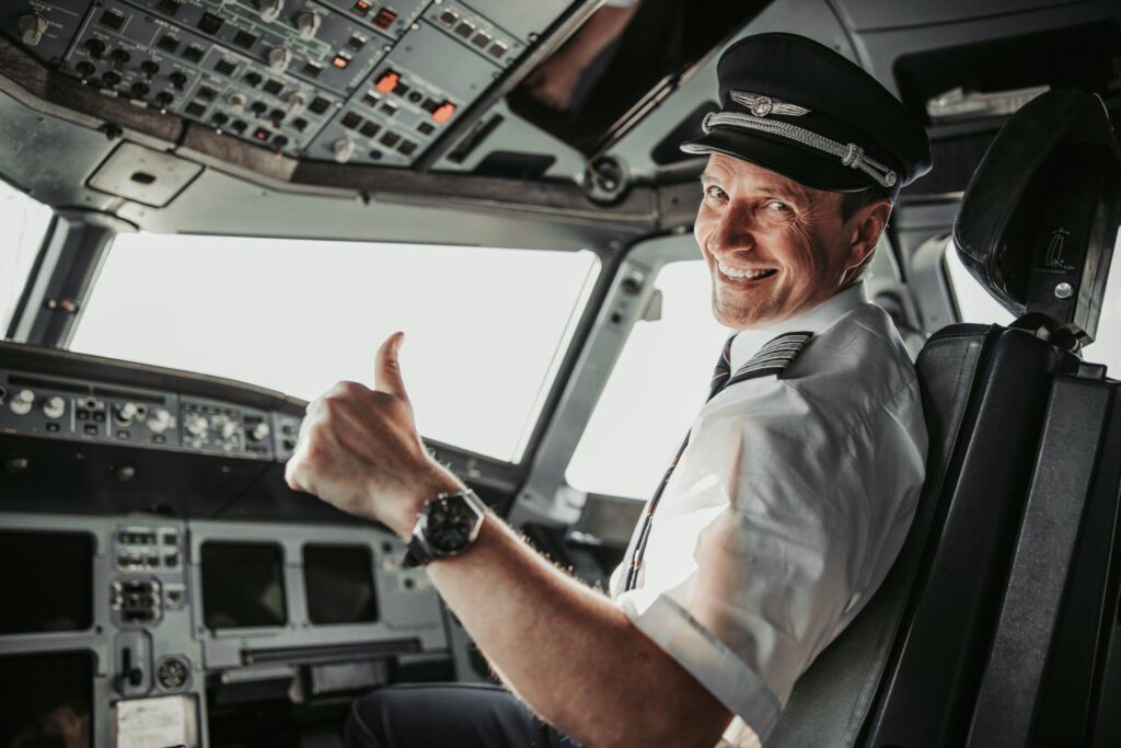 A happy international pilot gives a thumbs-up from the cockpit.