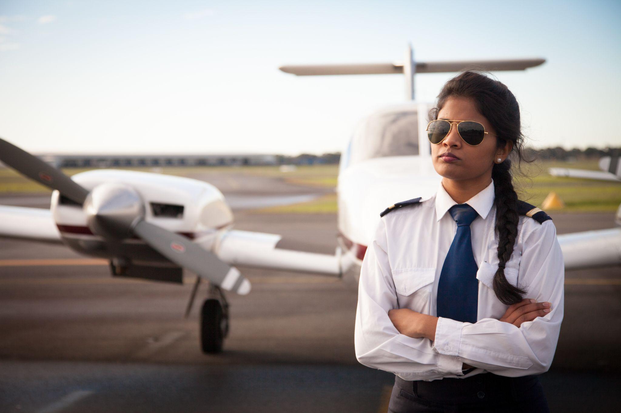 An international student pilot stands confidently after completing her private pilot license training at Kingsky.
