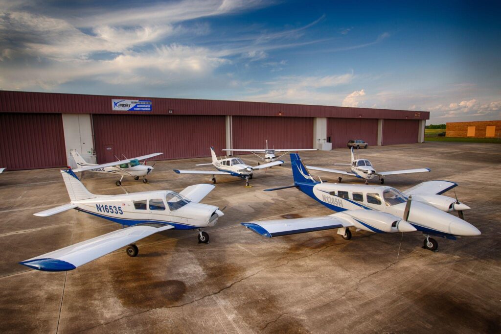 Pilot training aircrafts parked at Kingsky Flight Academy under a clear sky.