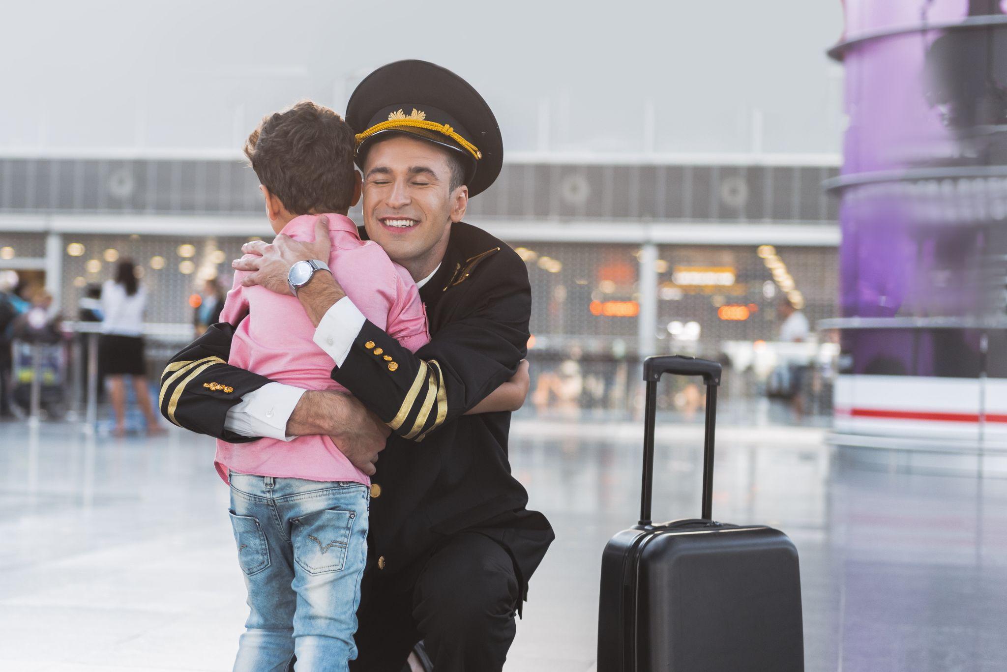 Cheerful smiling father embracing boy.